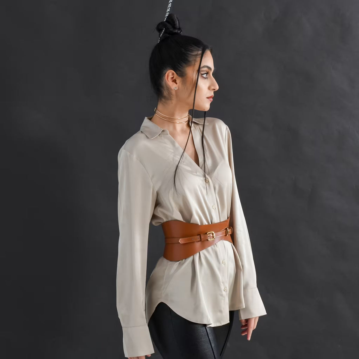 Aria Margo brown Italian leather slim corset belt worn over a beige button-down shirt for waist definition