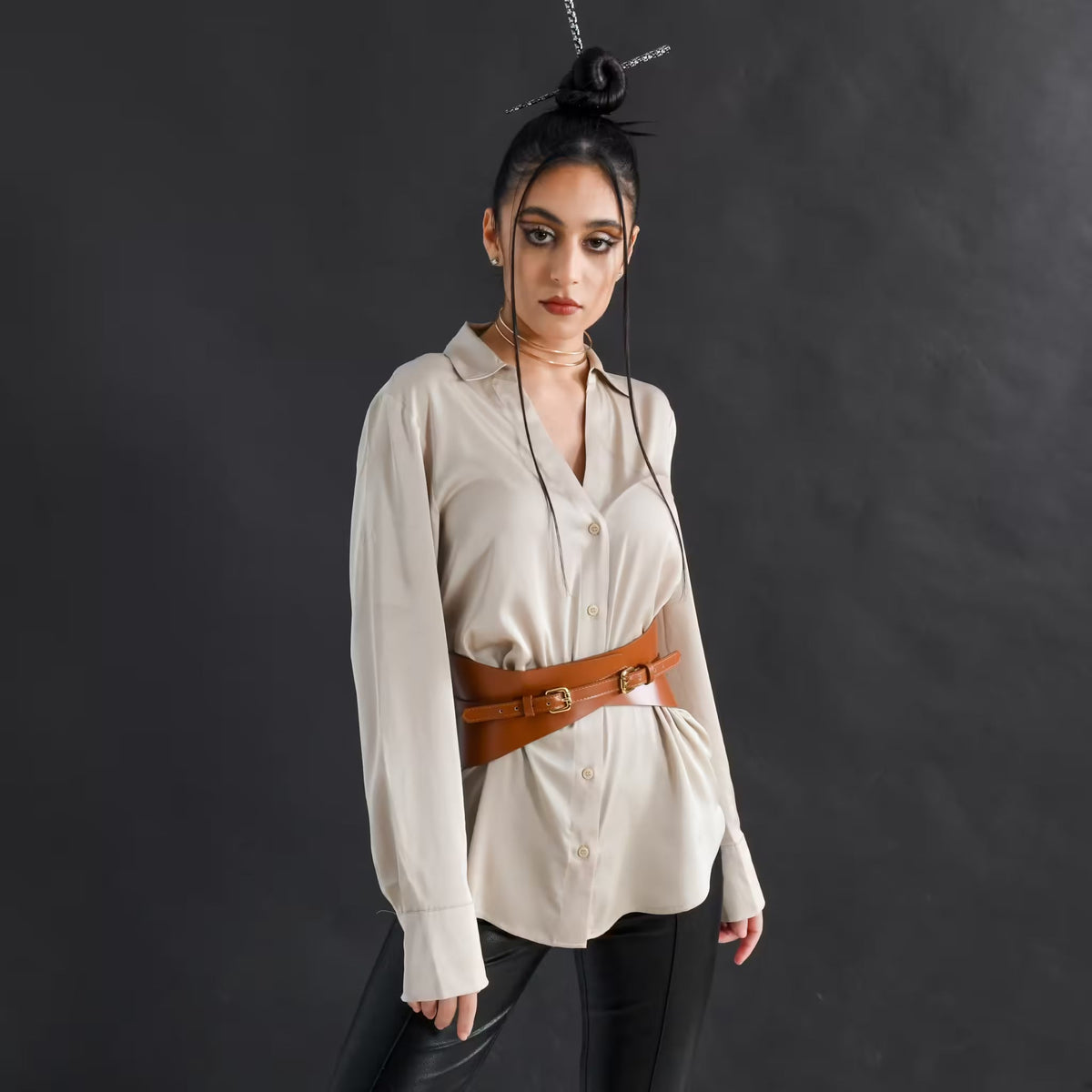 Aria Margo slim brown Italian leather corset belt worn over a beige button-down shirt on a model.