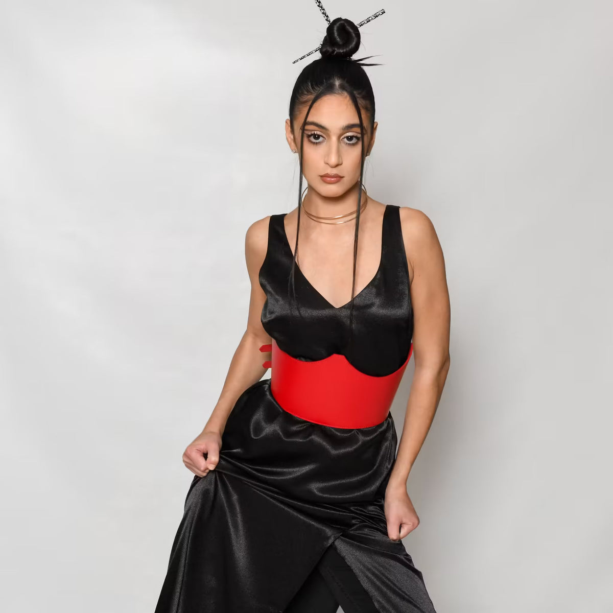 Aria Margo red Italian leather under-bust belt worn over a black satin dress for a structured, defined silhouette.
