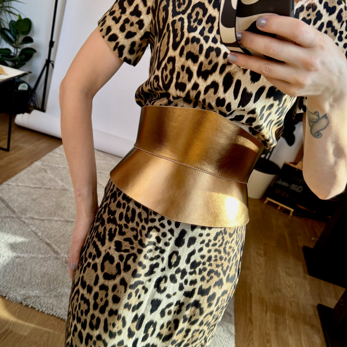 Aria Margo gold Italian leather corset belt with an hourglass silhouette worn over a leopard print dress