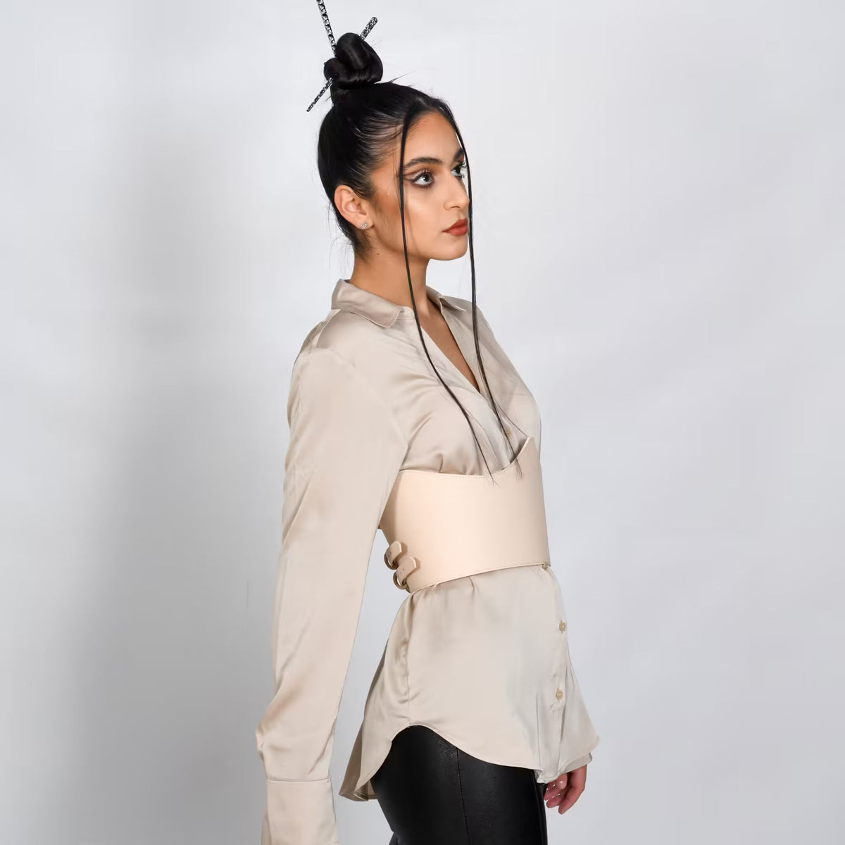 Model wearing an Aria Margo beige Italian leather under-bust belt over a silk shirt for a defined waistline