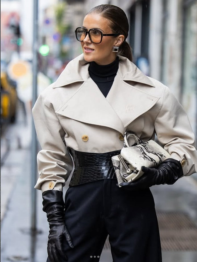 Aria Margo black croc-embossed leather hourglass corset belt worn over a beige cropped trench coat and black top.