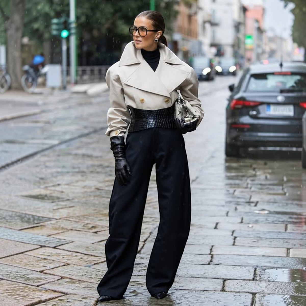 Aria Margo black croc-embossed leather hourglass corset belt worn over a beige trench coat and black trousers