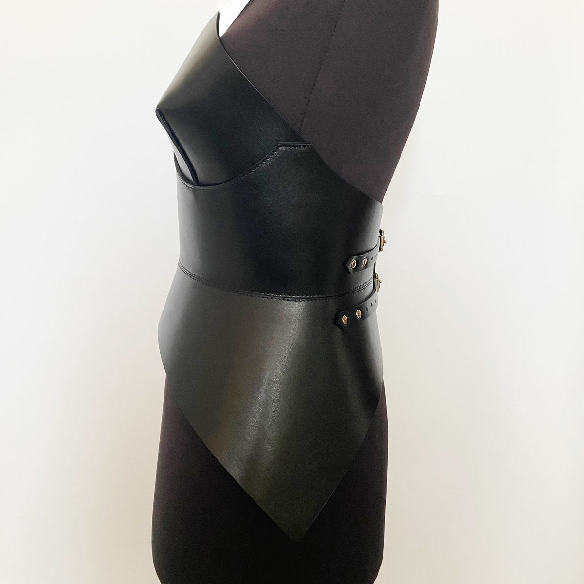 Aria Margo black Italian leather full body corset belt with polished buckles on a mannequin, side view.