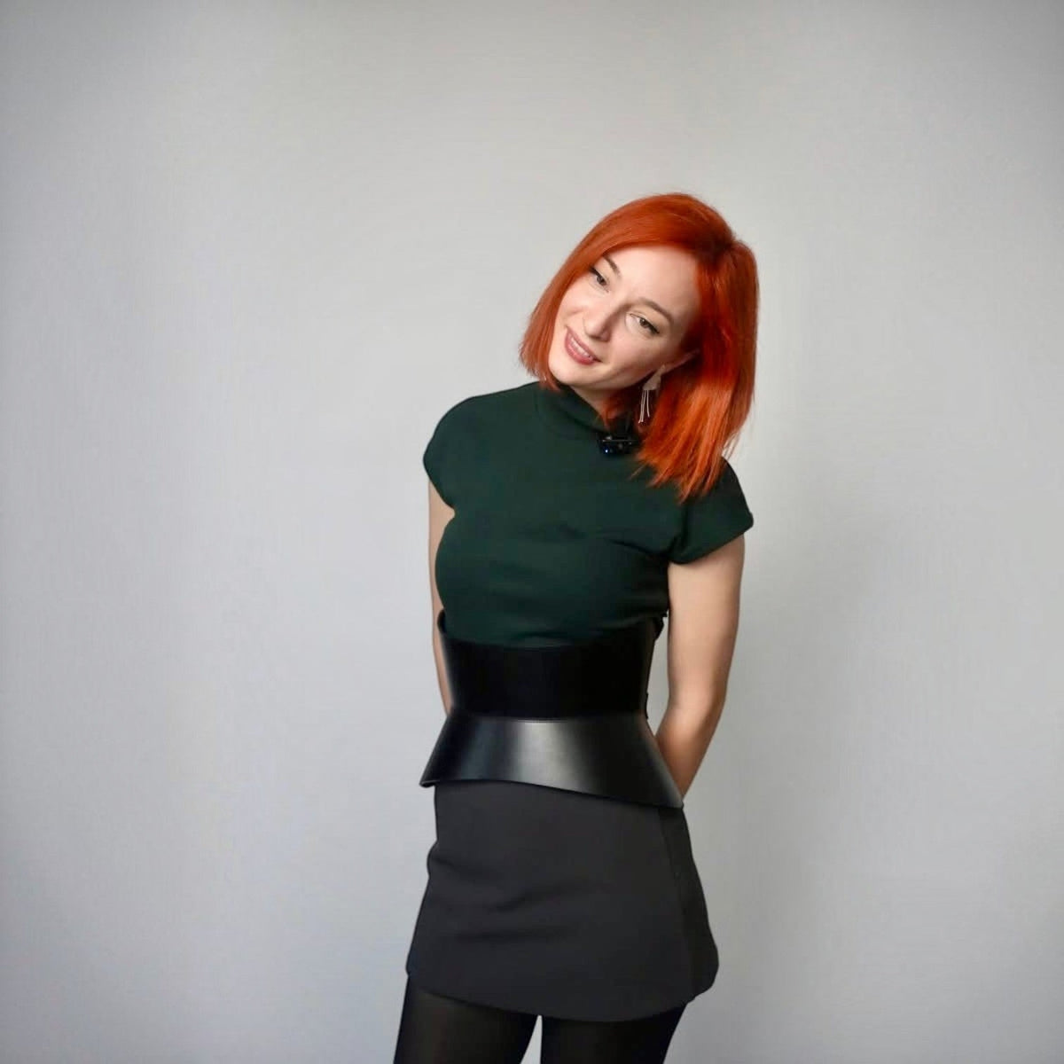 Aria Margo black Italian leather corset belt worn over a dark green top and skirt for a defined waistline