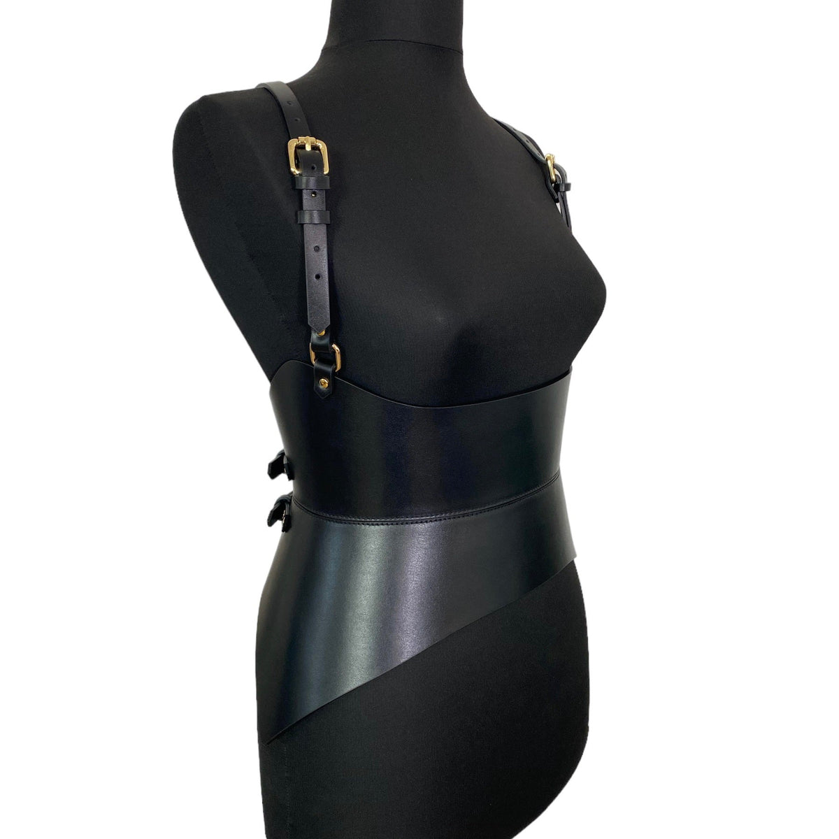 Aria Margo black leather corset belt with adjustable shoulder straps and gold buckles on a mannequin torso.