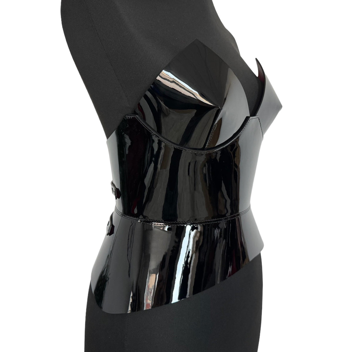Aria Margo black patent leather round body corset belt on a mannequin, side view showing high-shine finish.