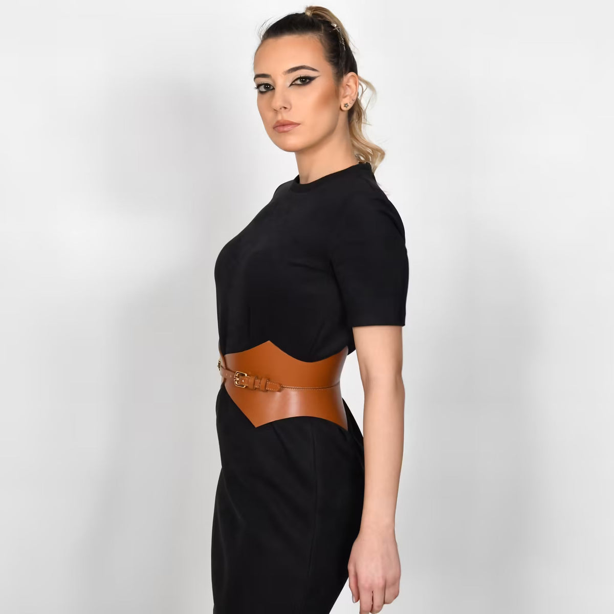 Aria Margo brown Italian leather Thorns corset belt worn over a black dress to define the waist