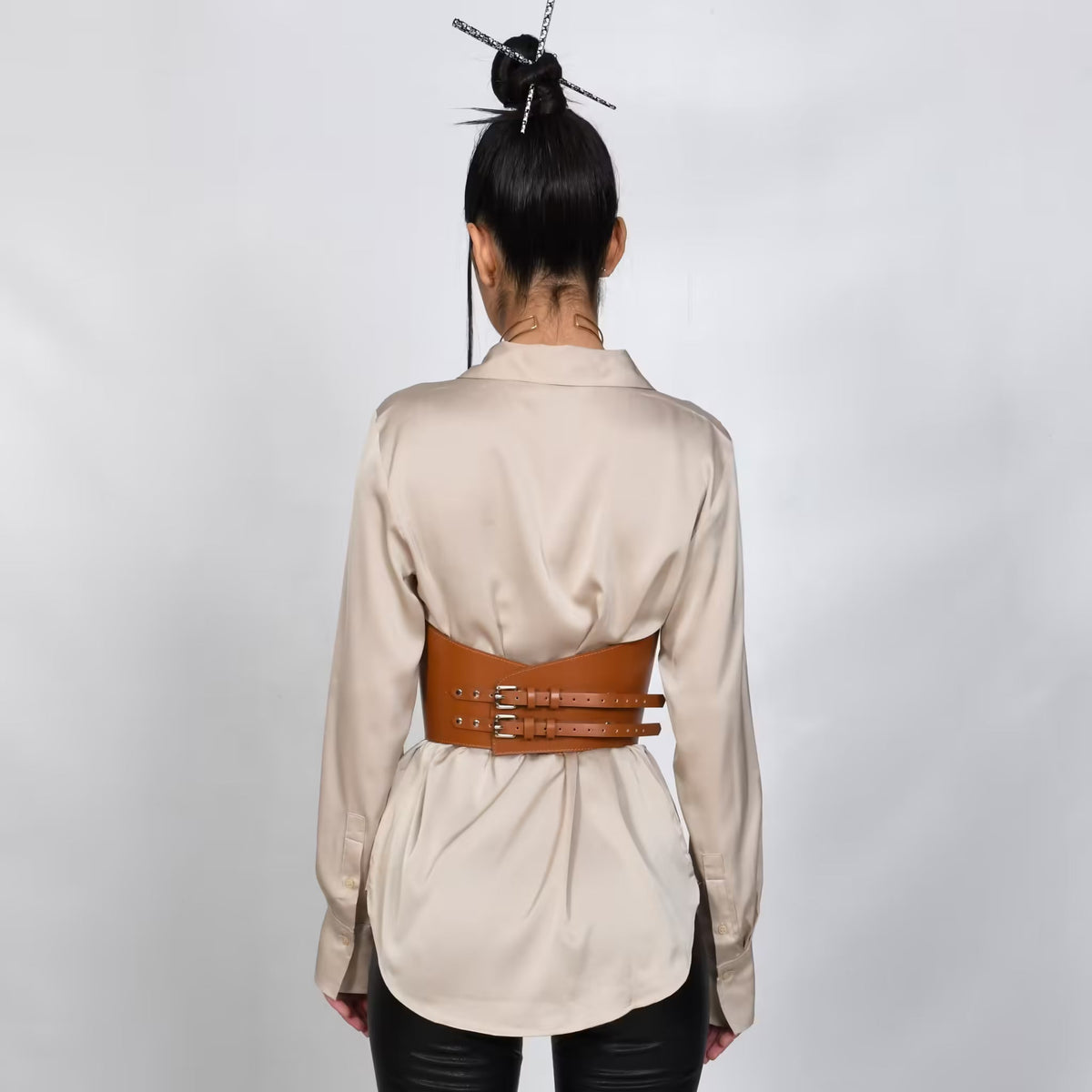 Aria Margo brown Italian leather under-bust belt with double buckles worn over a beige silk shirt, back view.