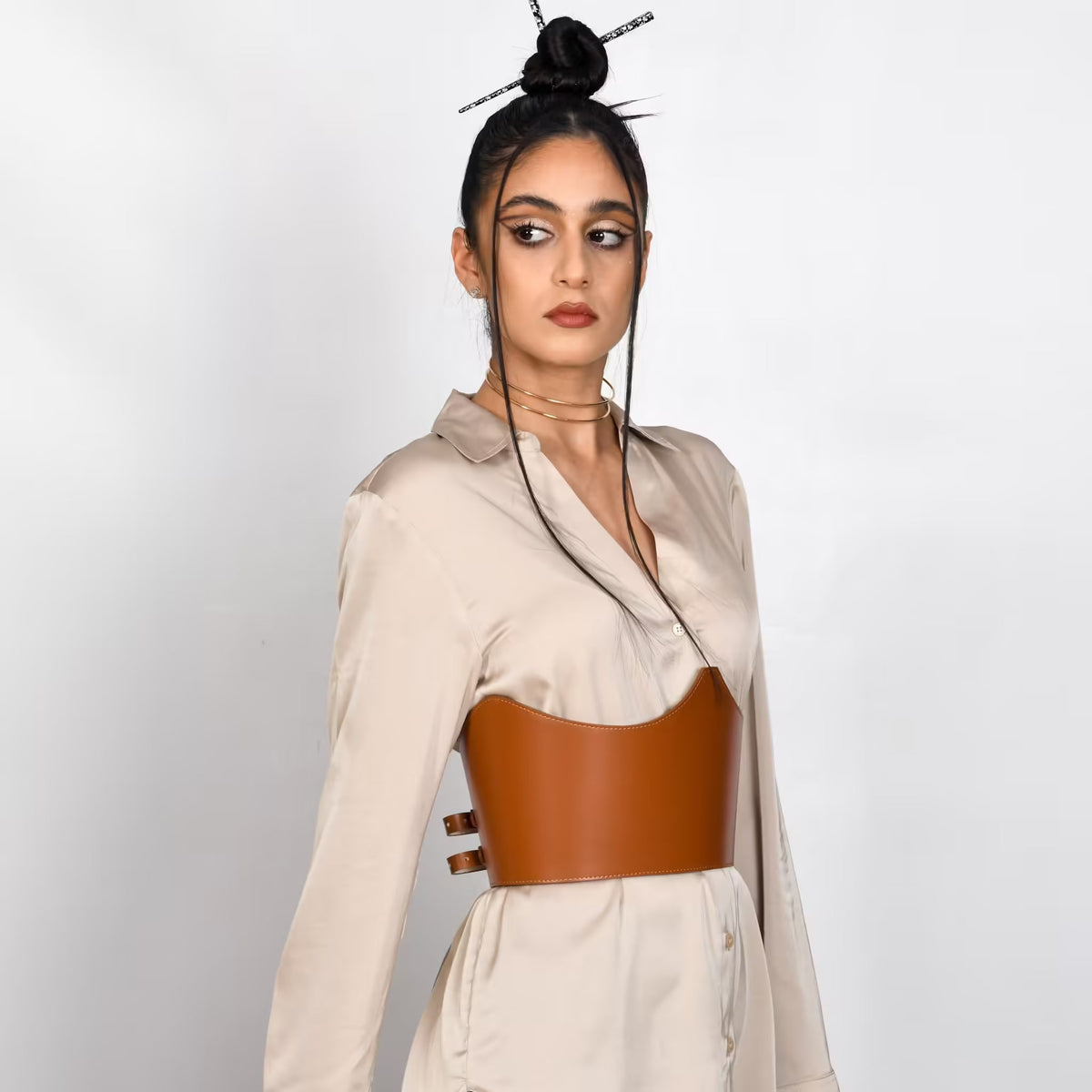 Aria Margo brown Italian leather under-bust belt worn over a beige satin shirt dress by a model.