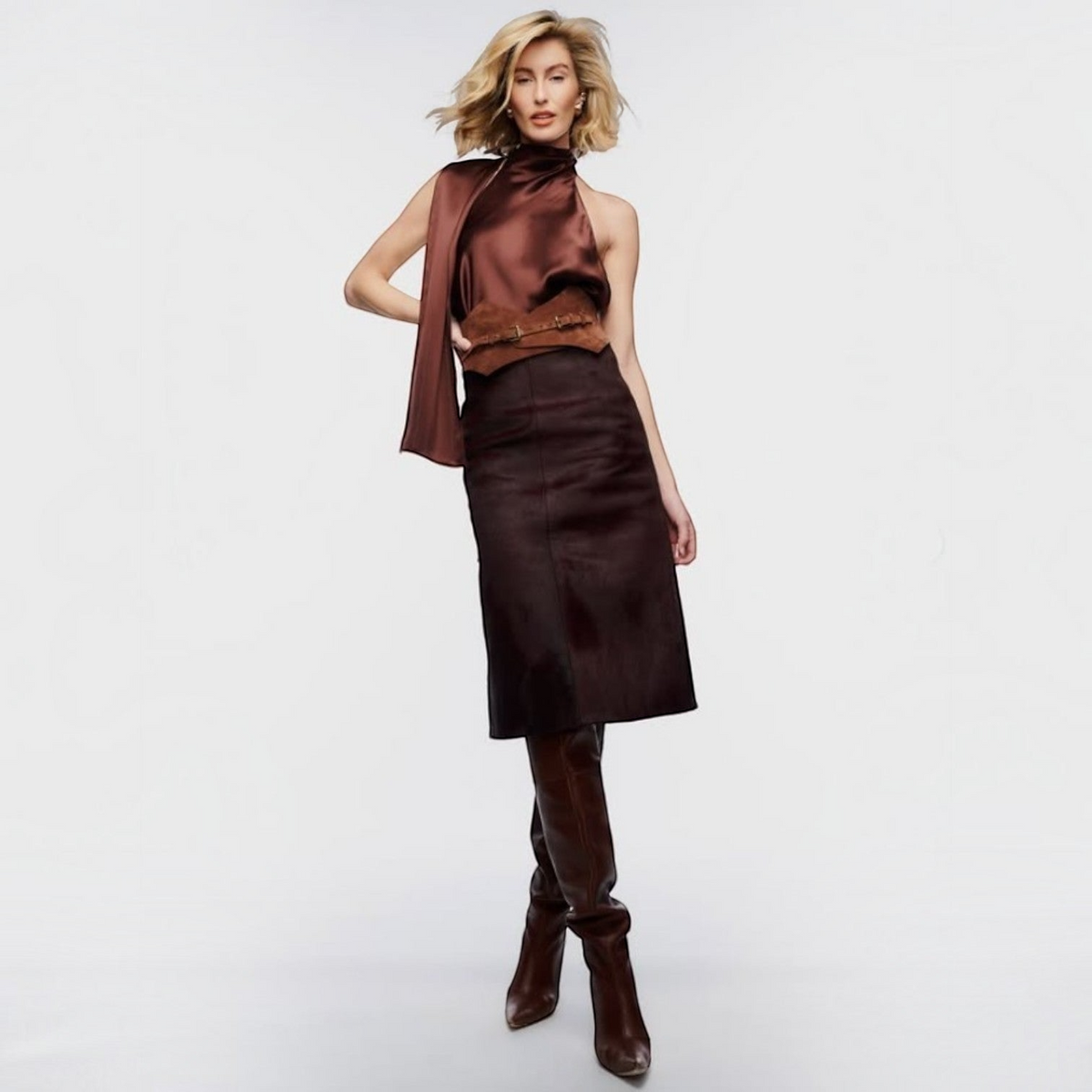 Aria Margo brown suede Thorns corset belt worn over a dark brown midi skirt and satin halter top