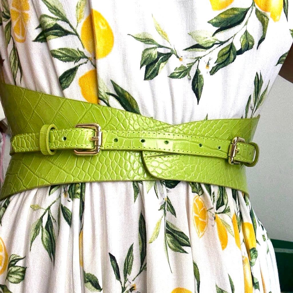 Aria Margo lime green croc-embossed leather corset belt worn over a white dress with a yellow lemon print.