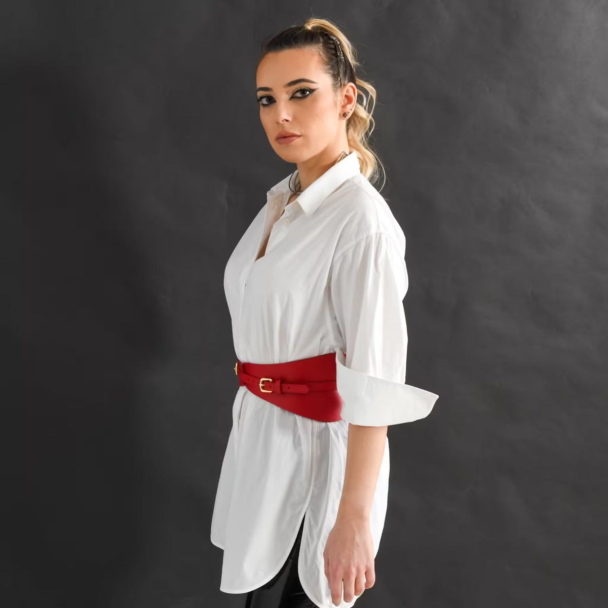 Aria Margo slim red Italian leather corset belt worn over a white button-down shirt by a model