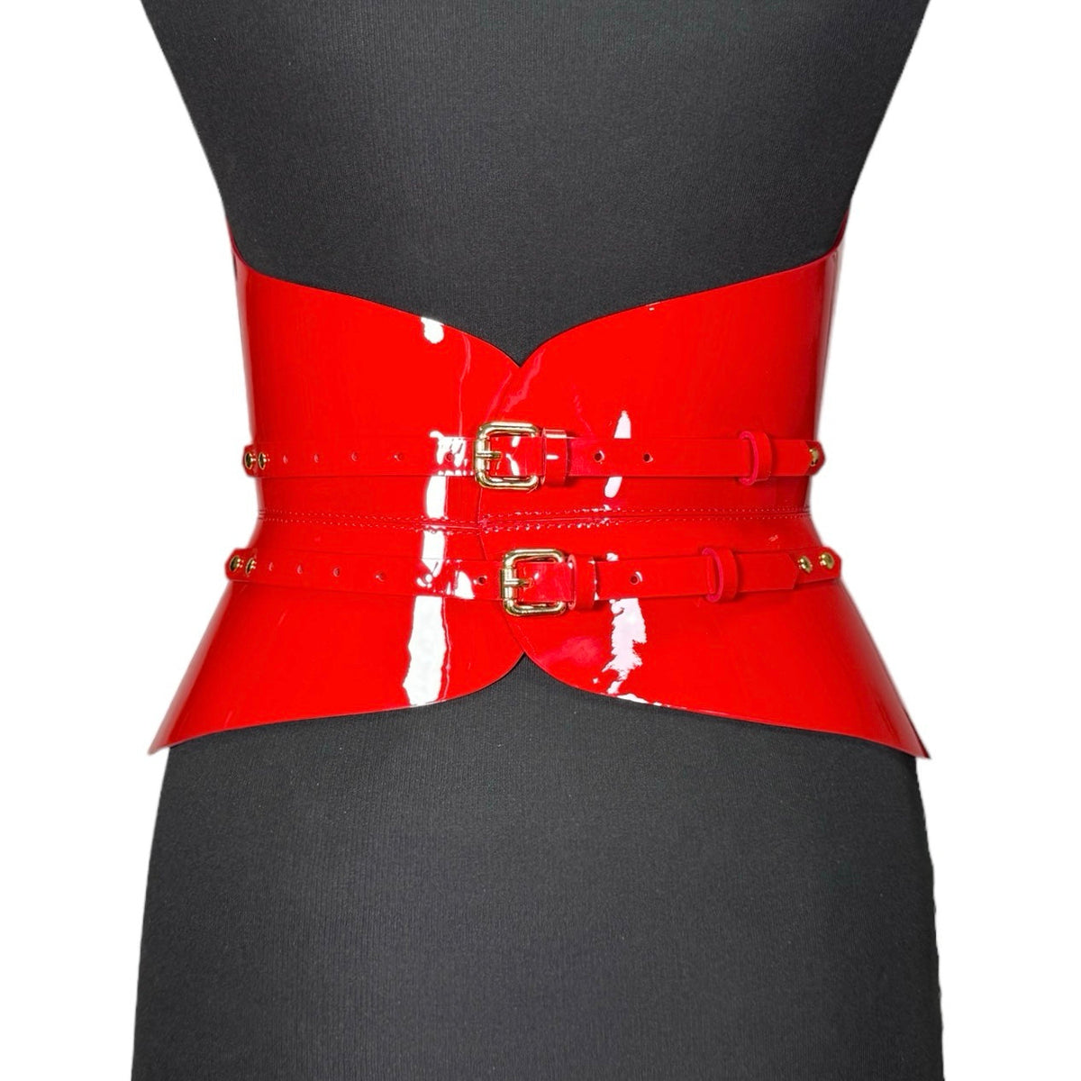 Aria Margo red patent leather corset with a high-shine finish, featuring two gold buckles on a mannequin.