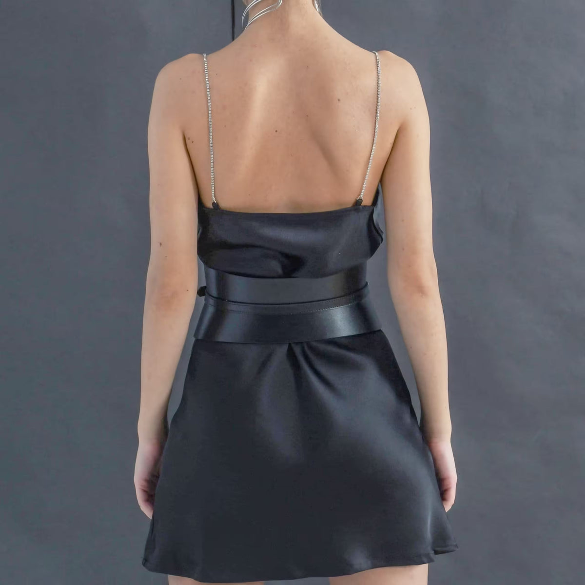 Aria Margo slim black Italian leather corset belt worn over a black satin dress, back view.